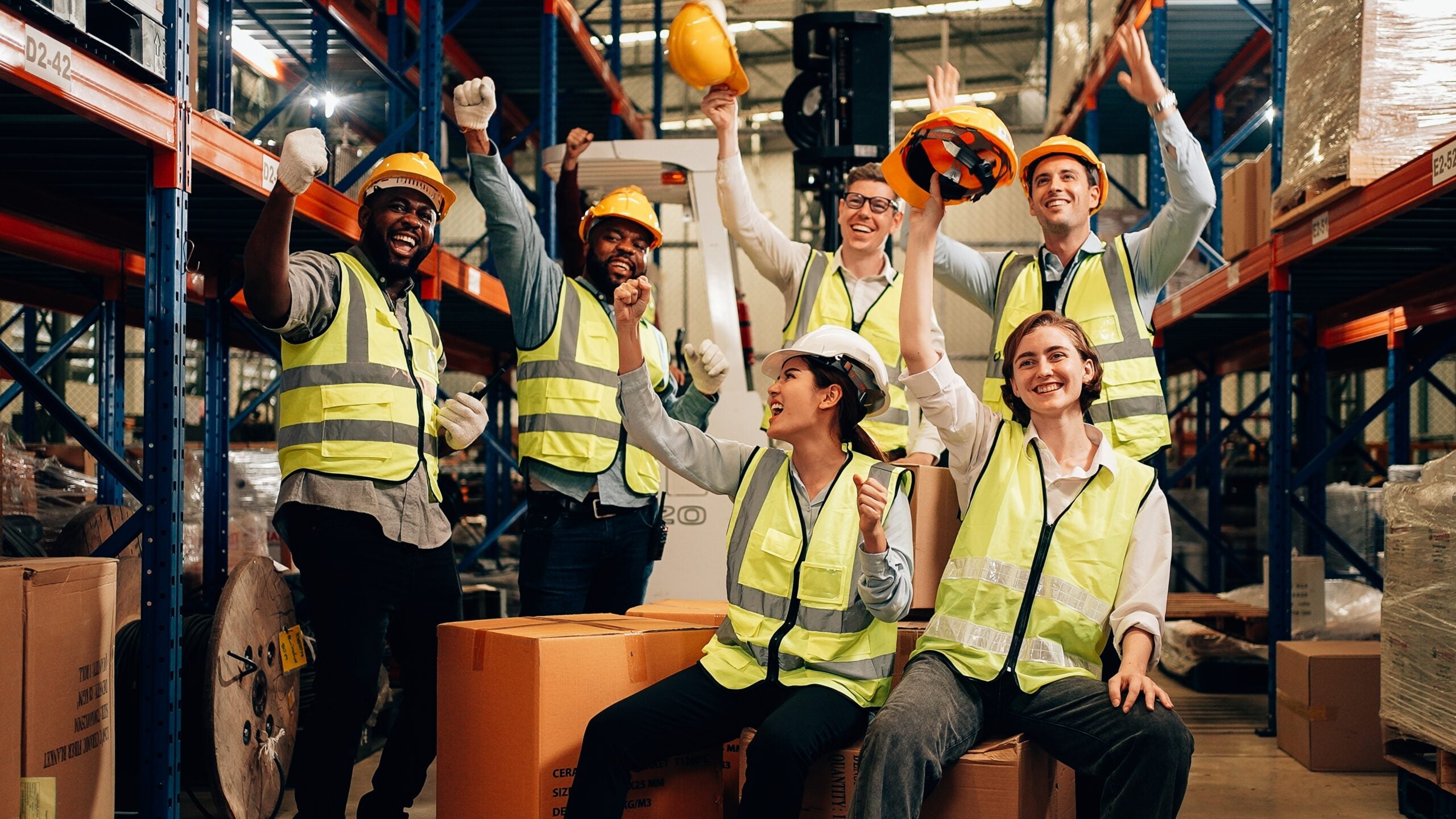 women and men in hardhats cheering